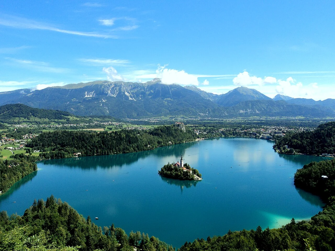 Lake Bled, Slovenia, framed by forested hills and Alpine mountains.