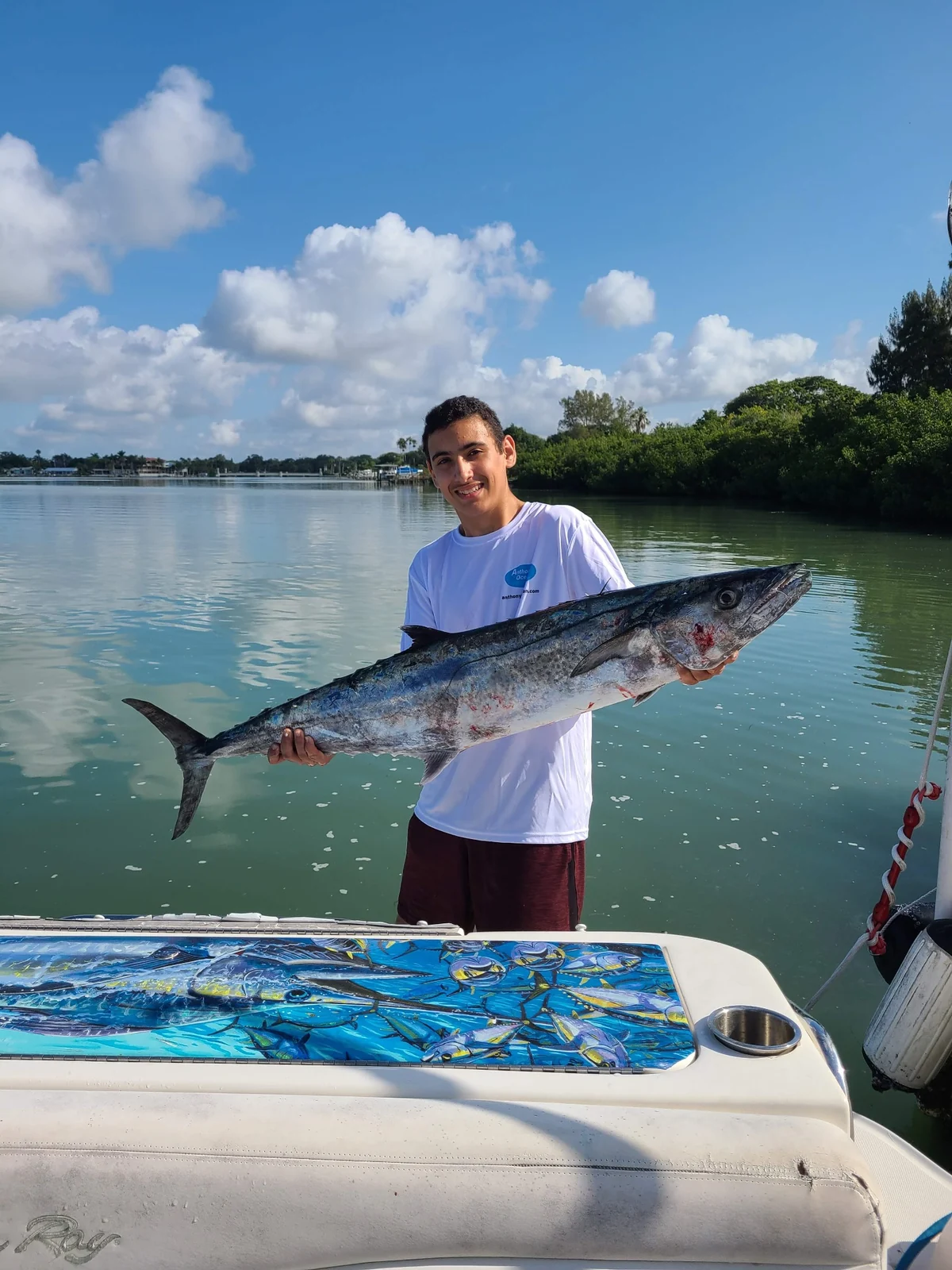 An angler holding a large king mackerel horizontally beside the water; owner’s personal photograph, with catch location and date unconfirmed.
