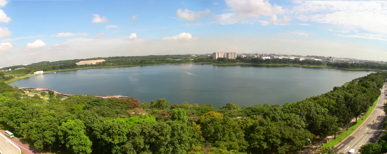 Historical 2010 panorama of Bedok Reservoir and its tree-lined shore in Singapore; not a map of current fishing zones.